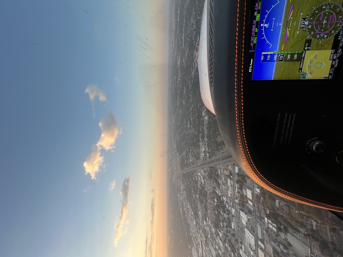 View over the city at sunset from the cockpit while flying